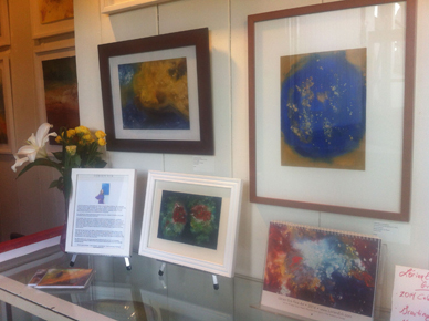 image of cosmic heart nebula painting hanging on wall with lorien's paintings
